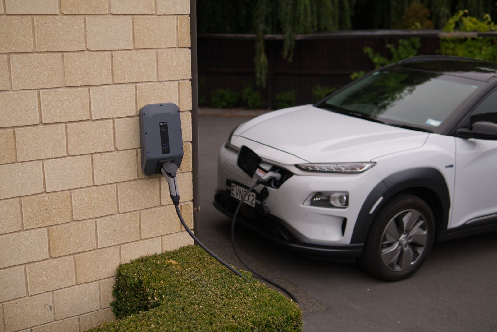 An EV charger installed on a home garage exterior wall